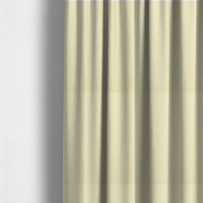The fabric used to create these made-to-measure curtains displays a dense, plush pile with a soft matte finish in a warm, buttery off-white shade. Its uniform texture and specialized water-resistant coating make it a luxurious yet practical choice for upholstery.