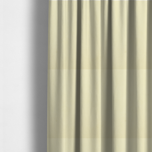 The fabric used to create these made-to-measure curtains displays a dense, plush pile with a soft matte finish in a warm, buttery off-white shade. Its uniform texture and specialized water-resistant coating make it a luxurious yet practical choice for upholstery.