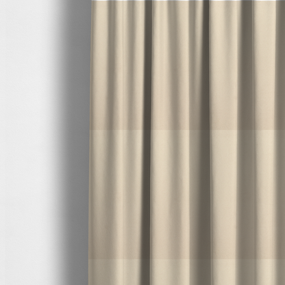 The fabric used to create these made-to-measure curtains features a fine, dense pile with a soft matte finish in a pale, sandy-beige tone. This high-performance upholstery material offers a luxurious feel with built-in moisture resistance for added durability.