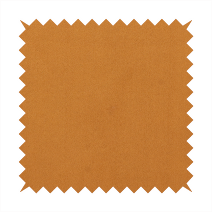 Annecy Water Repellent Velvet in Ochre. The fabric features a rich, dense pile with a soft matte finish in a warm, earthy mustard-orange tone. This high-performance upholstery material combines a luxurious feel with a specialized water-resistant coating for enhanced durability.