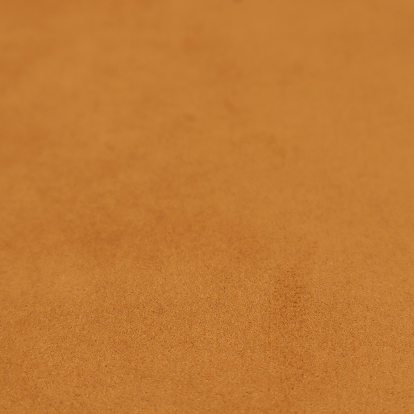 Annecy Water Repellent Velvet in Ochre. The fabric features a rich, dense pile with a soft matte finish in a warm, earthy mustard-orange tone. This high-performance upholstery material combines a luxurious feel with a specialized water-resistant coating for enhanced durability.