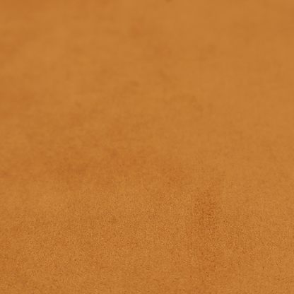 Annecy Water Repellent Velvet in Ochre. The fabric features a rich, dense pile with a soft matte finish in a warm, earthy mustard-orange tone. This high-performance upholstery material combines a luxurious feel with a specialized water-resistant coating for enhanced durability.