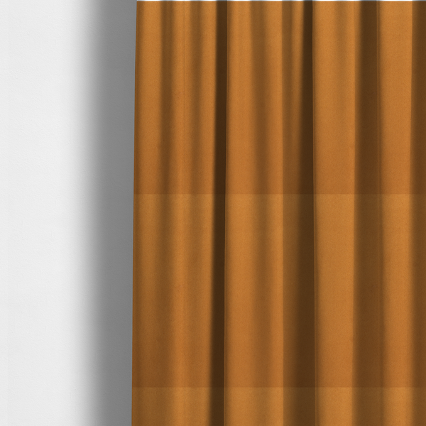 The fabric used to create these made-to-measure curtains features a rich, dense pile with a soft matte finish in a warm, earthy mustard-orange tone. This high-performance upholstery material combines a luxurious feel with a specialized water-resistant coating for enhanced durability.
