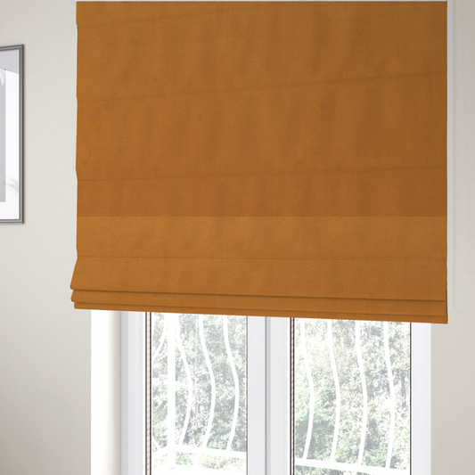 The fabric used to create these Roman blinds features a rich, dense pile with a soft matte finish in a warm, earthy mustard-orange tone. This high-performance upholstery material combines a luxurious feel with a specialized water-resistant coating for enhanced durability.