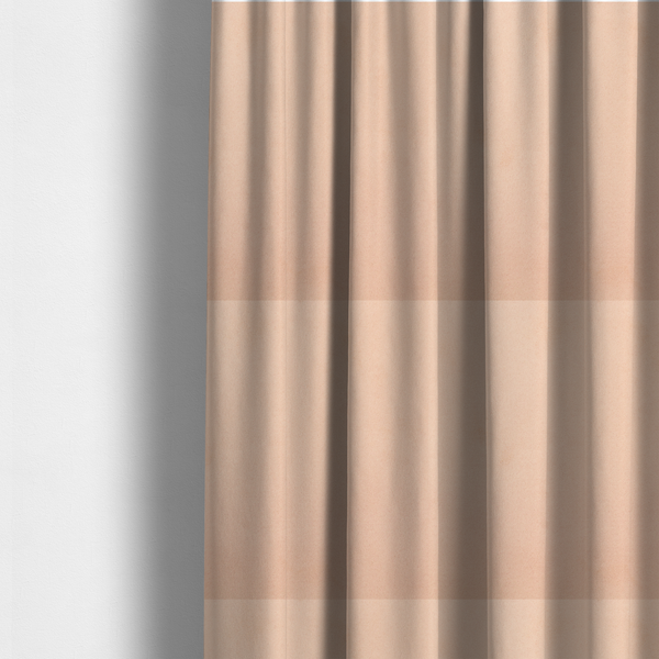 The fabric used to create these made-to-measure curtains features a dense, soft pile with a matte finish in a delicate, pale peachy-pink tone. This high-performance upholstery material offers a luxurious feel and a specialized water-resistant coating, making it both elegant and durable.