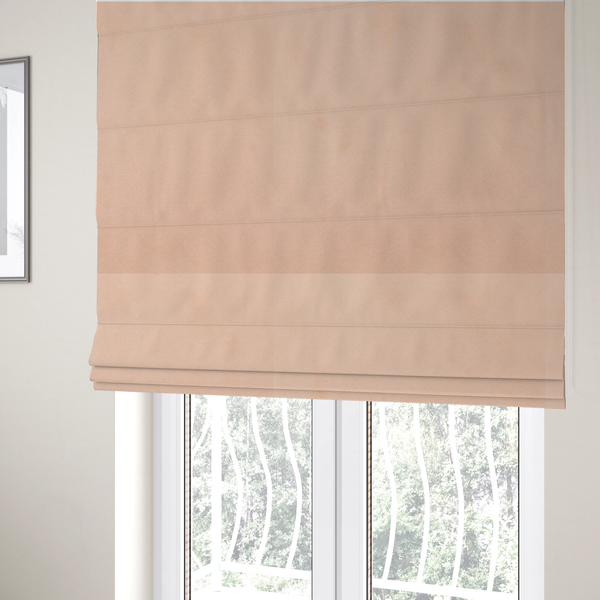 The fabric used to create these Roman blinds features a dense, soft pile with a matte finish in a delicate, pale peachy-pink tone. This high-performance upholstery material offers a luxurious feel and a specialized water-resistant coating, making it both elegant and durable.
