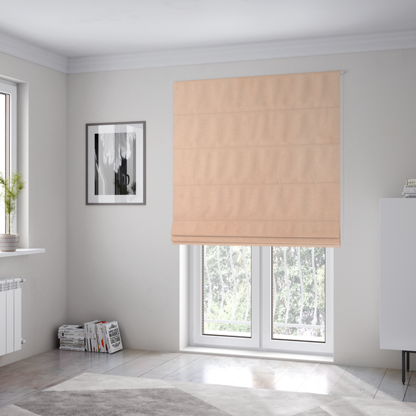 The fabric used to create these Roman blinds features a dense, soft pile with a matte finish in a delicate, pale peachy-pink tone. This high-performance upholstery material offers a luxurious feel and a specialized water-resistant coating, making it both elegant and durable.