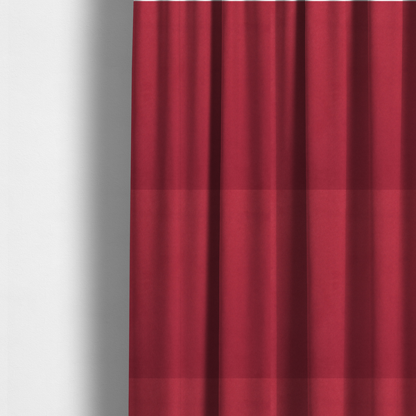 The fabric used to create these made-to-measure curtains features a dense, plush pile with a soft matte finish in a rich, vibrant crimson-red tone. This high-performance upholstery material offers a luxurious feel and a specialized water-resistant coating for superior durability and style.