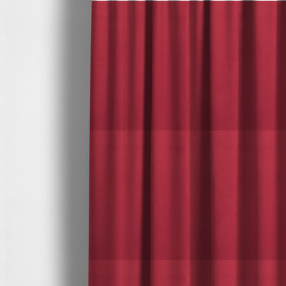 The fabric used to create these made-to-measure curtains features a dense, plush pile with a soft matte finish in a rich, vibrant crimson-red tone. This high-performance upholstery material offers a luxurious feel and a specialized water-resistant coating for superior durability and style.
