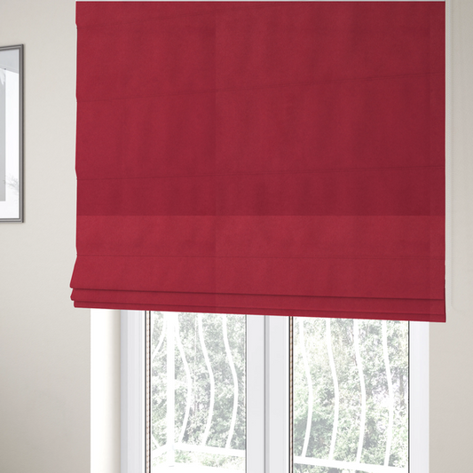 The fabric used to create these Roman blinds features a dense, plush pile with a soft matte finish in a rich, vibrant crimson-red tone. This high-performance upholstery material offers a luxurious feel and a specialized water-resistant coating for superior durability and style.
