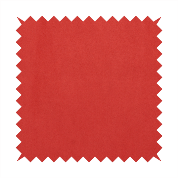 Annecy Water Repellent Velvet in Red. The fabric features a dense, plush pile with a soft matte finish in a bold, classic primary red. This high-performance upholstery material offers a luxurious feel and a specialized water-resistant coating for superior durability and a vibrant look.