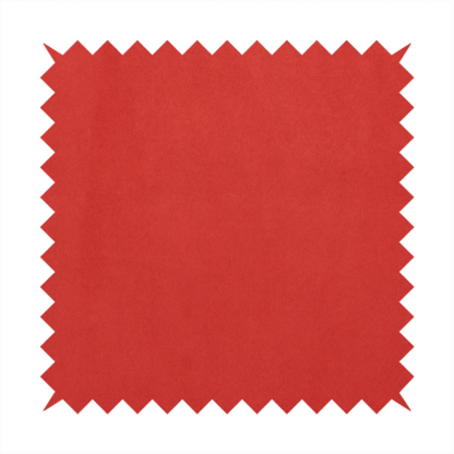 Annecy Water Repellent Velvet in Red. The fabric features a dense, plush pile with a soft matte finish in a bold, classic primary red. This high-performance upholstery material offers a luxurious feel and a specialized water-resistant coating for superior durability and a vibrant look.