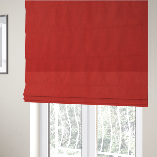 The fabric used to create these Roman blinds features a dense, plush pile with a soft matte finish in a bold, classic primary red. This high-performance upholstery material offers a luxurious feel and a specialized water-resistant coating for superior durability and a vibrant look.