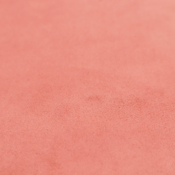 Annecy Water Repellent Velvet in Coral. The fabric features a dense, plush pile with a soft matte finish in a warm, vibrant pinkish-orange tone. This high-performance upholstery material offers a luxurious feel combined with a specialized water-resistant coating for enhanced durability and a fresh, modern look.