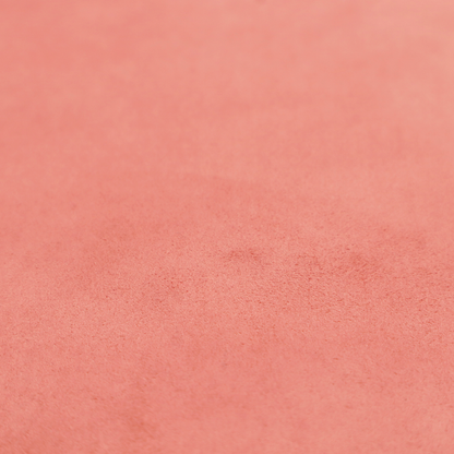 Annecy Water Repellent Velvet in Coral. The fabric features a dense, plush pile with a soft matte finish in a warm, vibrant pinkish-orange tone. This high-performance upholstery material offers a luxurious feel combined with a specialized water-resistant coating for enhanced durability and a fresh, modern look.