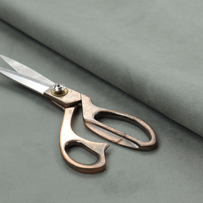 Annecy Water Repellent Velvet in Sage. The fabric features a dense, plush pile with a soft matte finish in a sophisticated, muted earthy green. This high-performance upholstery material offers a luxurious feel and a specialized water-resistant coating for enhanced durability and a natural, calming aesthetic.