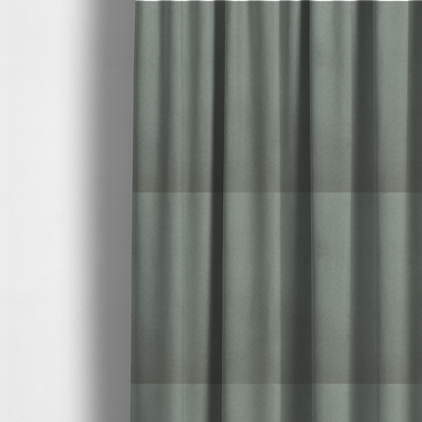 The fabric used to create these made-to-measure curtains features a dense, plush pile with a soft matte finish in a sophisticated, muted earthy green. This high-performance upholstery material offers a luxurious feel and a specialized water-resistant coating for enhanced durability and a natural, calming aesthetic.