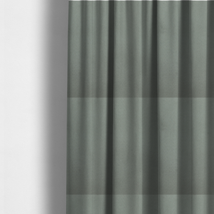 The fabric used to create these made-to-measure curtains features a dense, plush pile with a soft matte finish in a sophisticated, muted earthy green. This high-performance upholstery material offers a luxurious feel and a specialized water-resistant coating for enhanced durability and a natural, calming aesthetic.