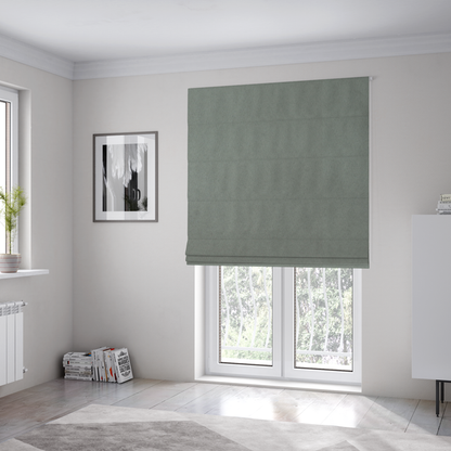 The fabric used to create these Roman blinds features a dense, plush pile with a soft matte finish in a sophisticated, muted earthy green. This high-performance upholstery material offers a luxurious feel and a specialized water-resistant coating for enhanced durability and a natural, calming aesthetic.