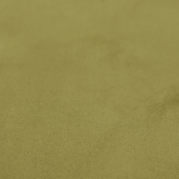 Annecy Water Repellent Velvet in Olive. The fabric features a dense, plush pile with a soft matte finish in a warm, mossy green tone. This high-performance upholstery material offers a luxurious feel and a specialized water-resistant coating for superior durability and a timeless, organic look.