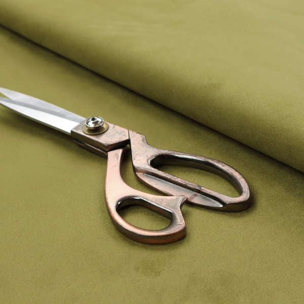 Annecy Water Repellent Velvet in Olive. The fabric features a dense, plush pile with a soft matte finish in a warm, mossy green tone. This high-performance upholstery material offers a luxurious feel and a specialized water-resistant coating for superior durability and a timeless, organic look.