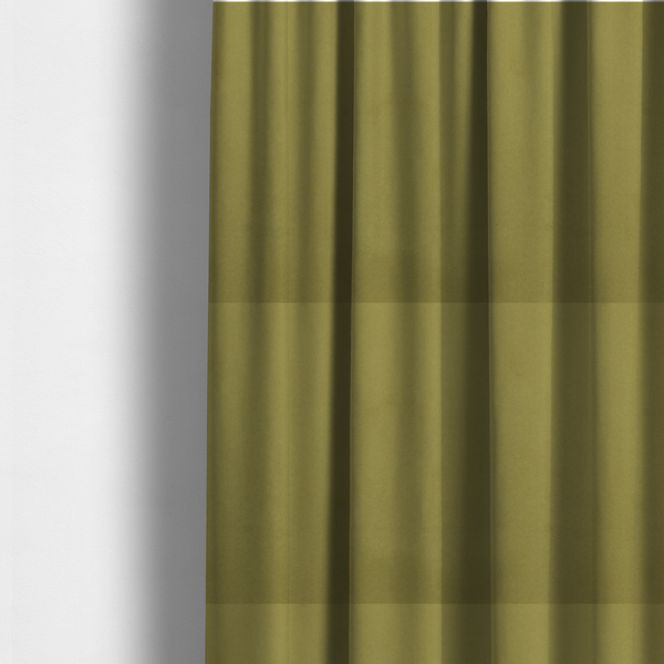 The fabric used to create these made-to-measure curtains features a dense, plush pile with a soft matte finish in a warm, mossy green tone. This high-performance upholstery material offers a luxurious feel and a specialized water-resistant coating for superior durability and a timeless, organic look.
