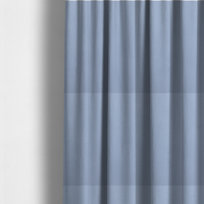The fabric used to create these made-to-measure curtains showcases a dense, uniform pile in a soft, serene powder blue. This high-performance upholstery material combines a luxurious matte aesthetic with a water-resistant finish, perfect for durable yet stylish furniture.