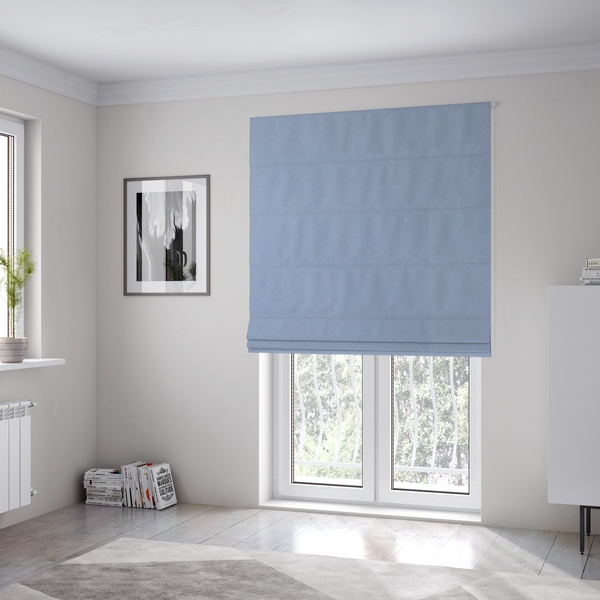 The fabric used to create these Roman blinds showcases a dense, uniform pile in a soft, serene powder blue. This high-performance upholstery material combines a luxurious matte aesthetic with a water-resistant finish, perfect for durable yet stylish furniture.