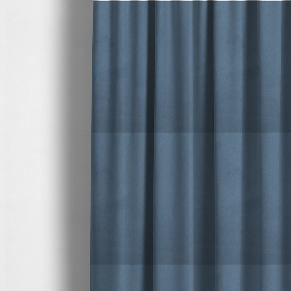 The fabric used to create these made-to-measure curtains features a dense, plush pile with a soft matte finish in a sophisticated, mid-toned greyish-blue. This high-performance upholstery material offers a luxurious feel and a specialized water-resistant coating for superior durability and a calm, modern look.