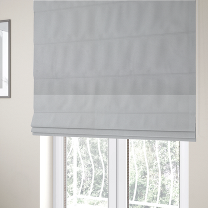 The fabric used to create these Roman blinds features a dense, plush pile with a soft matte finish in a bright, clean light grey. This high-performance upholstery material offers a luxurious texture and a specialized water-resistant coating for a modern, durable aesthetic.