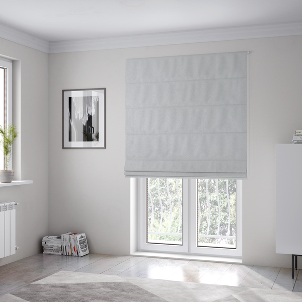 The fabric used to create these Roman blinds features a dense, plush pile with a soft matte finish in a bright, clean light grey. This high-performance upholstery material offers a luxurious texture and a specialized water-resistant coating for a modern, durable aesthetic.