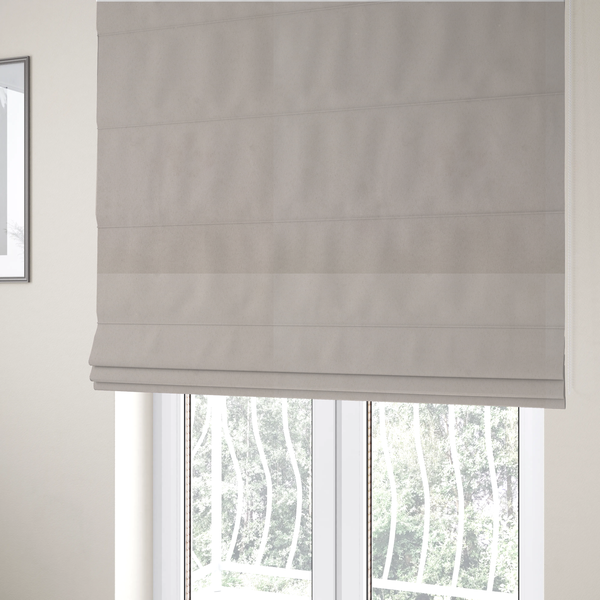 The fabric used to create these Roman blinds features a dense, plush pile with a soft matte finish in a sophisticated, pale neutral grey. This high-performance upholstery material offers a luxurious feel and a specialized water-resistant coating for superior durability and a timeless, elegant look.