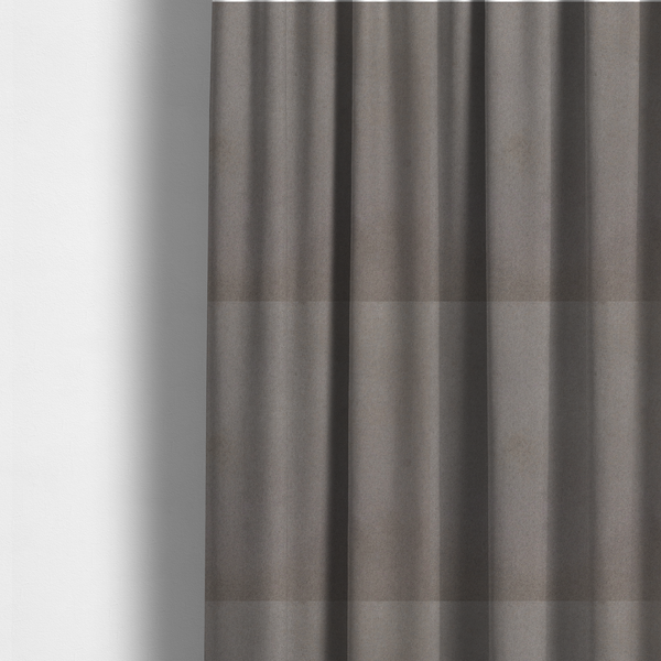 The fabric used to create these made-to-measure curtains features a dense, uniform pile with a soft matte finish in a deep, moody brownish-grey. This high-performance upholstery material offers a luxurious texture and a specialized water-resistant coating for a sophisticated, durable finish.
