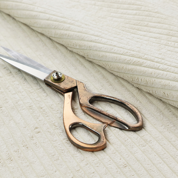 This fabric is an off-white or cream-coloured corduroy featuring a consistent, vertical ribbed texture.