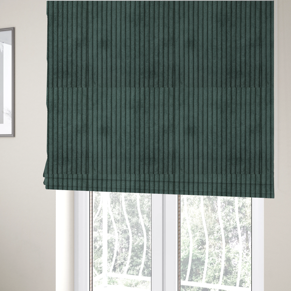 The fabric used to create these Roman blinds is a teal-green corduroy featuring a consistent vertical ribbed texture.
