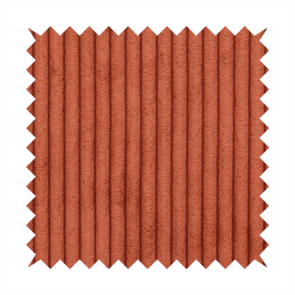This fabric is a terracotta or burnt orange corduroy featuring a consistent vertical ribbed texture.