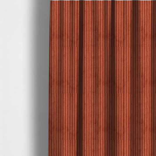 The fabric used to create these made-to-measure curtains is a terracotta or burnt orange corduroy featuring a consistent vertical ribbed texture.