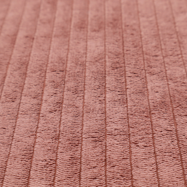 This fabric is a muted rose or dusty terracotta corduroy featuring a consistent vertical ribbed texture.