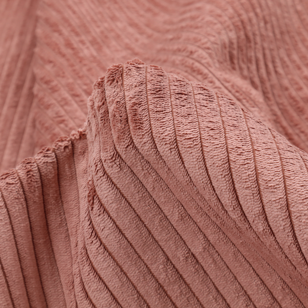 This fabric is a muted rose or dusty terracotta corduroy featuring a consistent vertical ribbed texture.