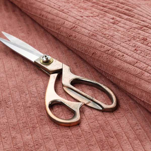 This fabric is a muted rose or dusty terracotta corduroy featuring a consistent vertical ribbed texture.