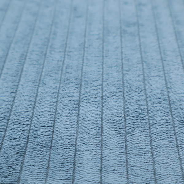 This fabric is a soft, dusty blue corduroy featuring a consistent vertical ribbed texture.