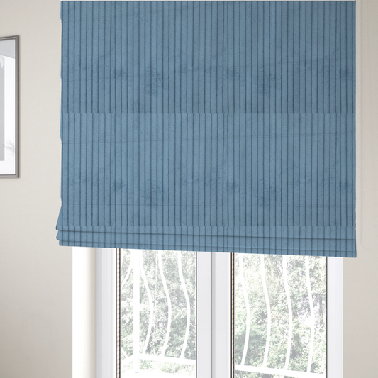 The fabric used to create these Roman blinds is a soft, dusty blue corduroy featuring a consistent vertical ribbed texture.