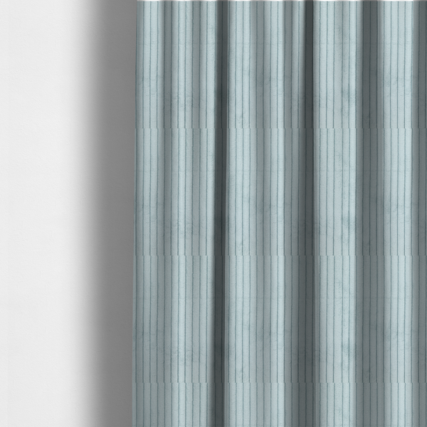 The fabric used to create these made-to-measure curtains is a pale, icy blue corduroy featuring a consistent vertical ribbed texture.