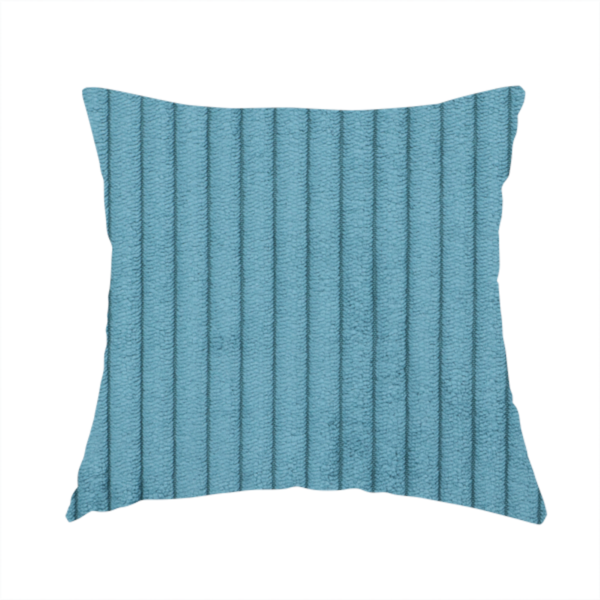 The fabric used to create this handmade cushion is a medium blue corduroy featuring a consistent vertical ribbed texture.