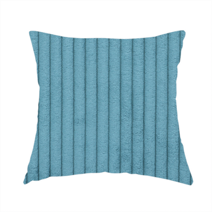 The fabric used to create this handmade cushion is a medium blue corduroy featuring a consistent vertical ribbed texture.