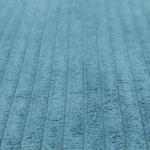 This fabric is a medium blue corduroy featuring a consistent vertical ribbed texture.