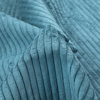 This fabric is a medium blue corduroy featuring a consistent vertical ribbed texture.