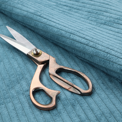 This fabric is a medium blue corduroy featuring a consistent vertical ribbed texture.
