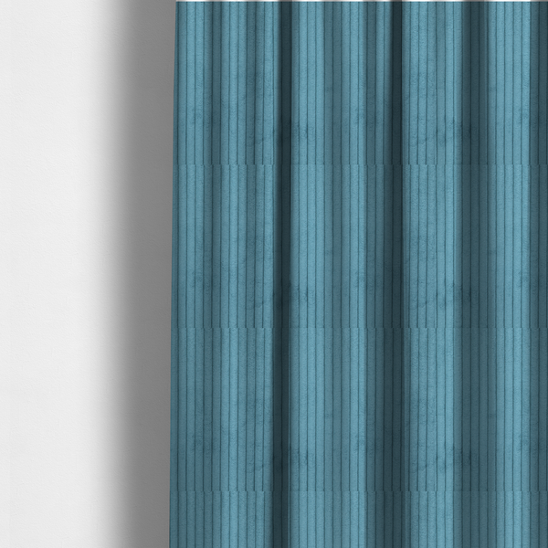 The fabric used to create these made-to-measure curtains is a medium blue corduroy featuring a consistent vertical ribbed texture.