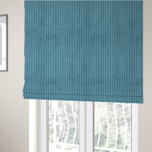 The fabric used to create these Roman blinds is a medium blue corduroy featuring a consistent vertical ribbed texture.